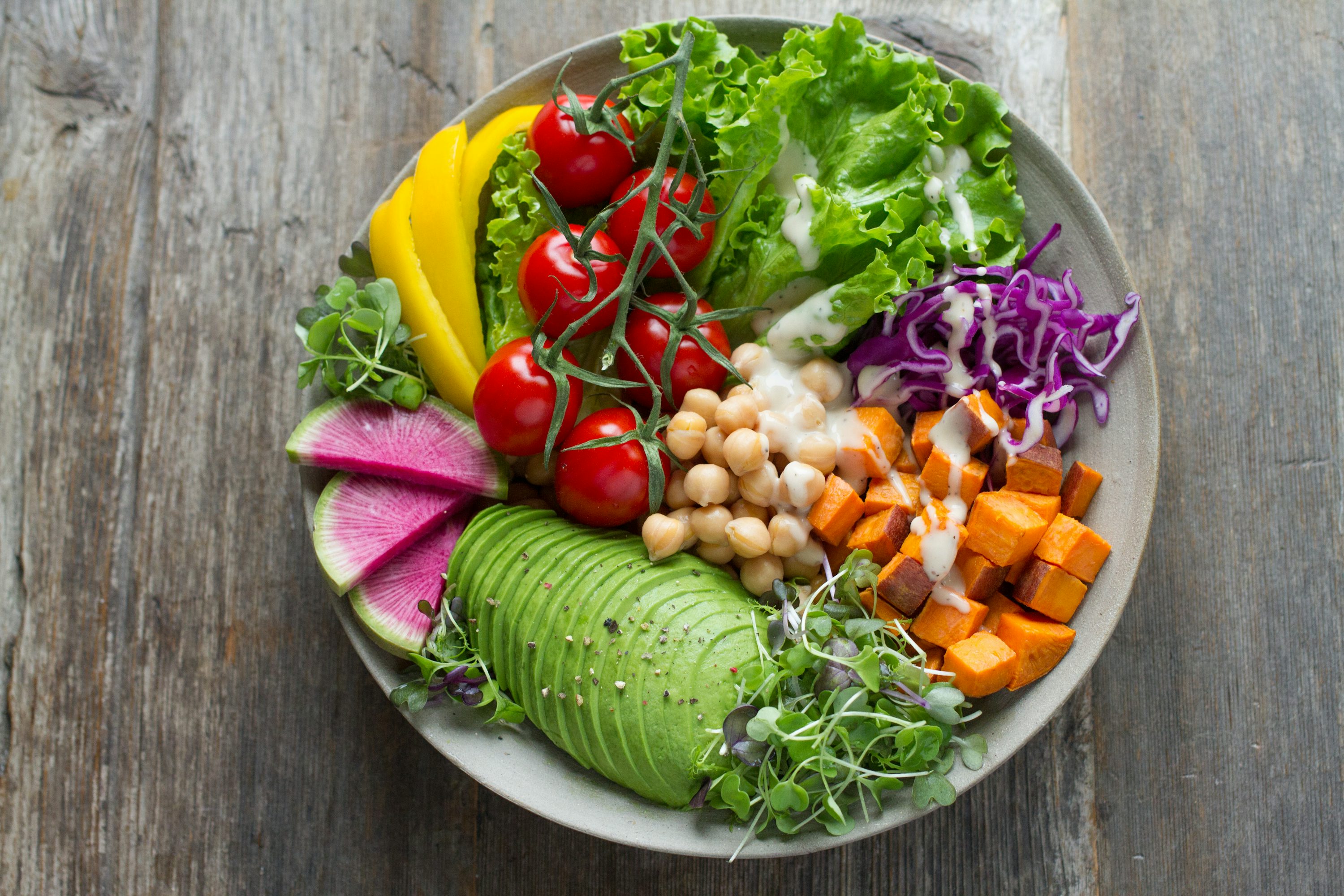 Salatschüssel mit Tomaten, Kichererbsen, Avocado und weiterem Gemüse